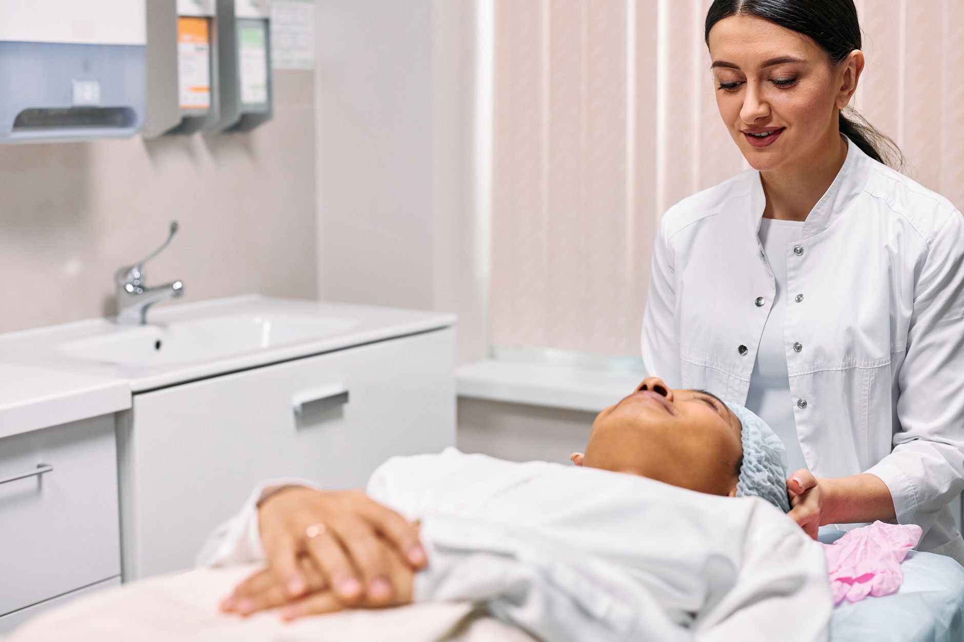 Juruterapi memberikan rawatan penjagaan kulit wajah kepada seorang wanita di klinik.